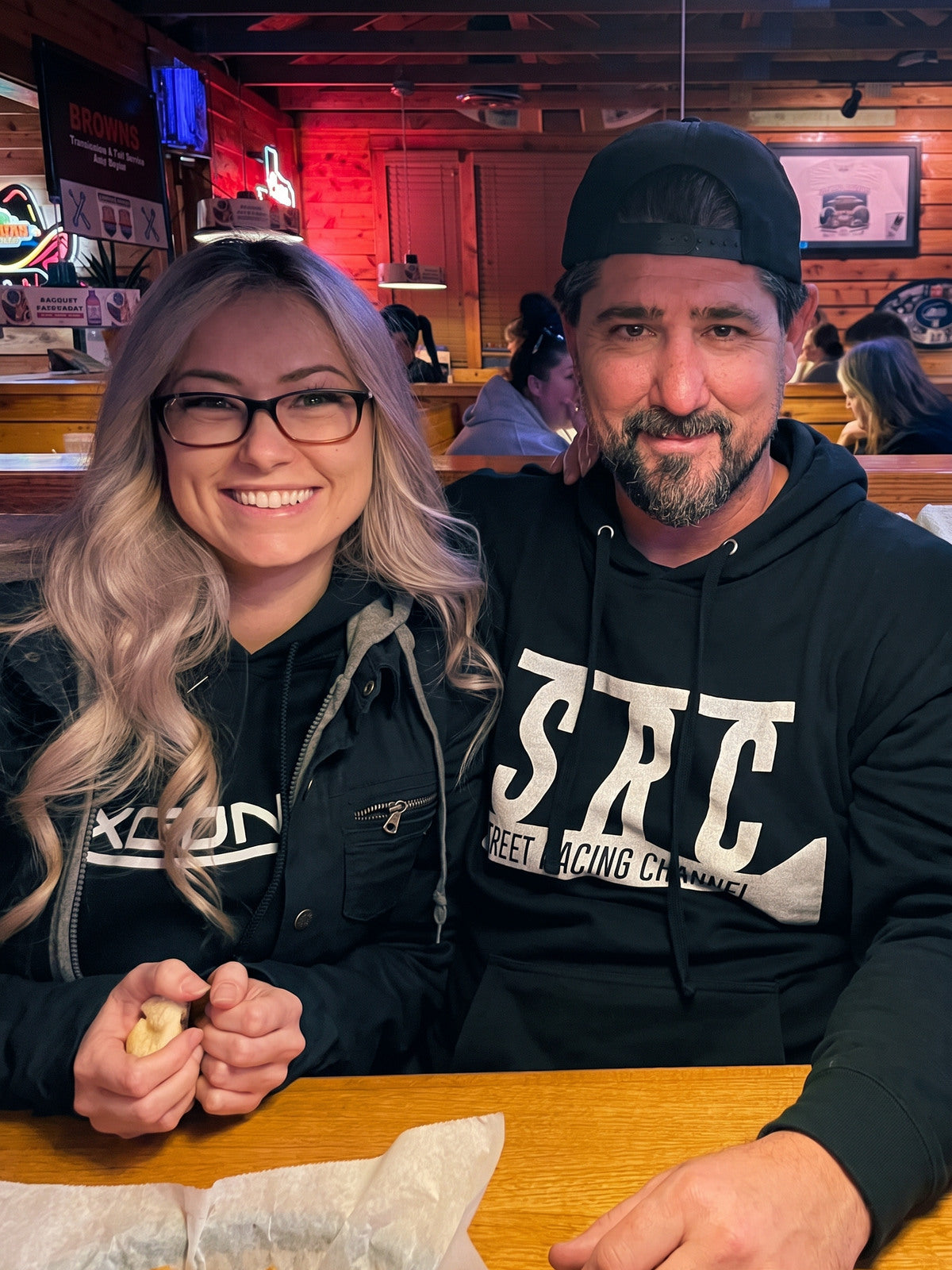 A smiling couple seated together at a restaurant.